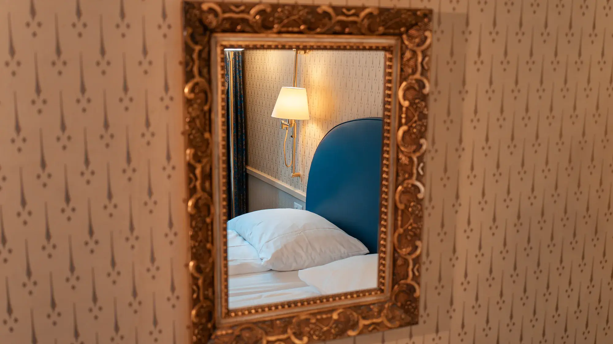 Goldspiegel mit blauem Bett-Kopfteil